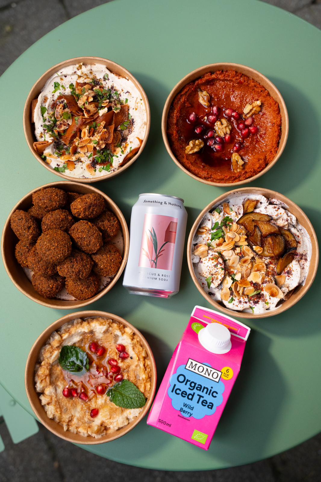 Bovenaanzicht van fattehbowls, falafel en drankjes bij Nabäti Eatery Rotterdam